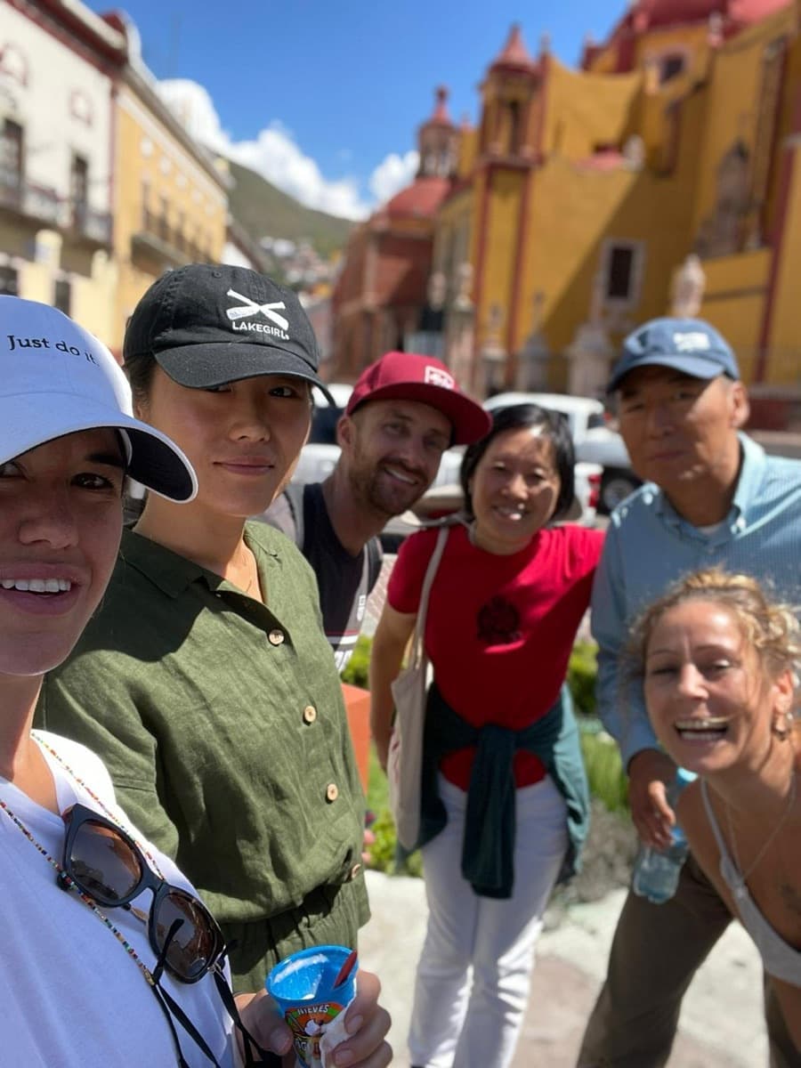 A group of guests taking a selfie in front of a yellow church