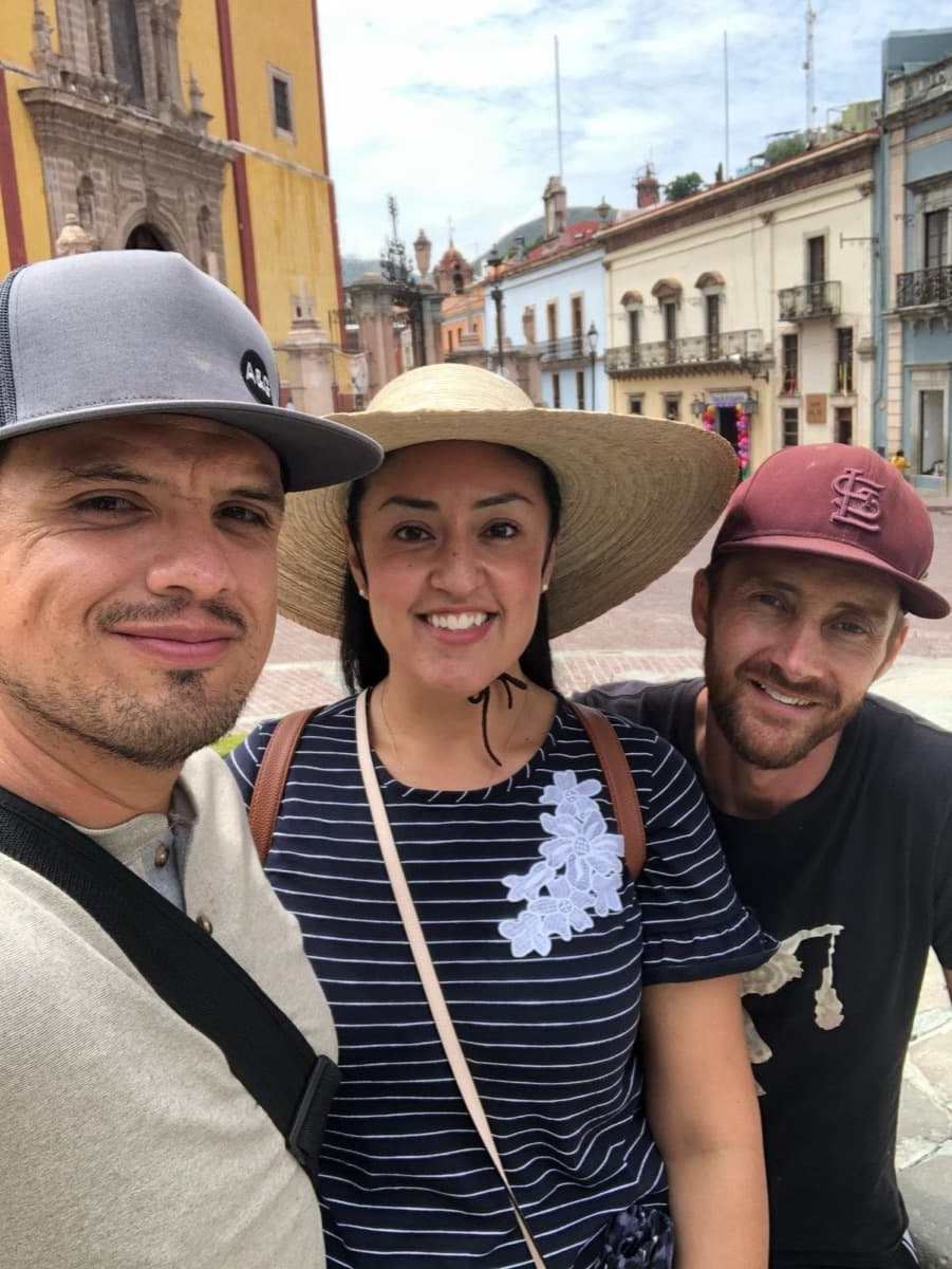 Three guests smiling in front of the yellow Basilica in Guanajuato